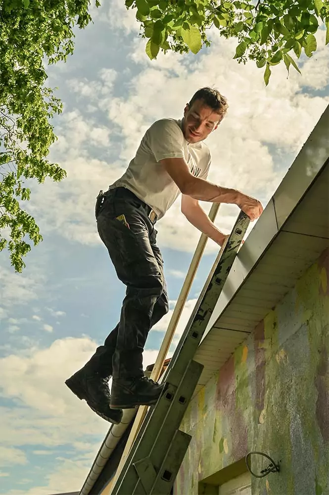 Mitarbeiter des Bauunternehmens Nordwerk Rügen auf einer Leiter während einer Haus-Sanierung.