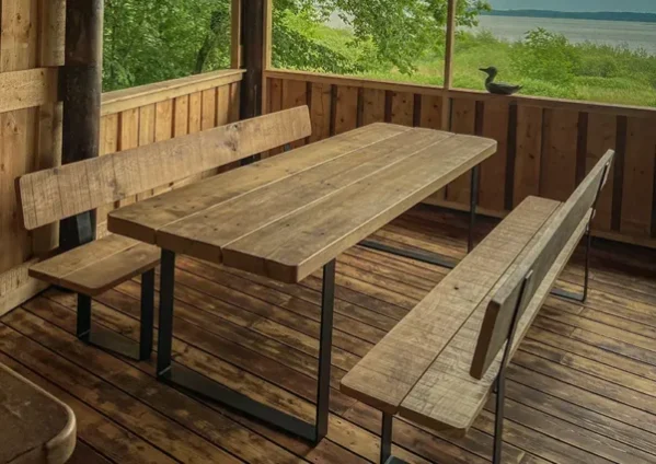 Massivholztisch mit Bänken im rustikalen Grillhaus aus Holz – gefertigt von NordWerk Rügen