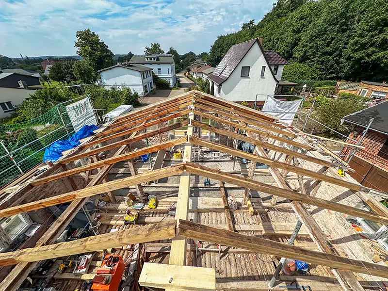 Offener Dachstuhl während der Kernsanierung in Lietzow auf Rügen – Blick auf Holztragwerk und Baustelle