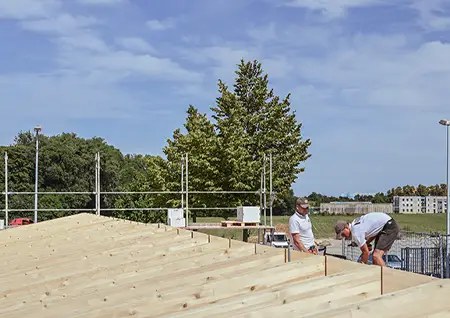 Zwei Zimmerer von NordWerk arbeiten auf einer neu errichteten Dachfläche aus Holz auf Rügen