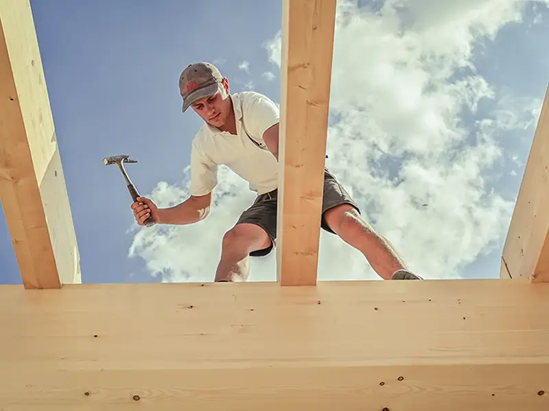 Zimmerer von NordWerk arbeitet an einer Dachkonstruktion aus Holz auf Rügen